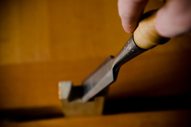 Stanley 750 Wood Chisel Cutting A Dovetail Joint In A Woodworking Workbench Vise With Engraving In Focus