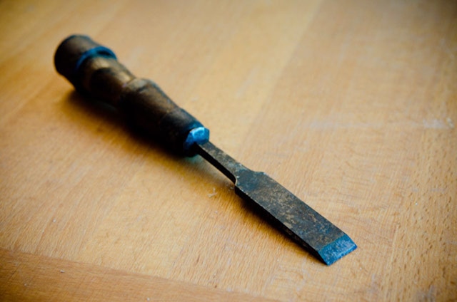 Antique Tang Wood Chisel Laying On A Woodworking Workbench 