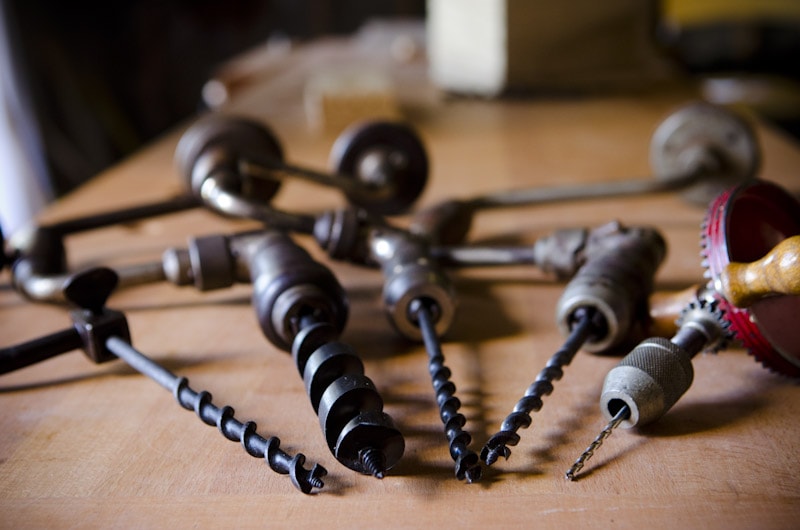 Brace And Bit And Antique Hand Drill Or Manual Hand Drill Collection On A Wood Work Bench
