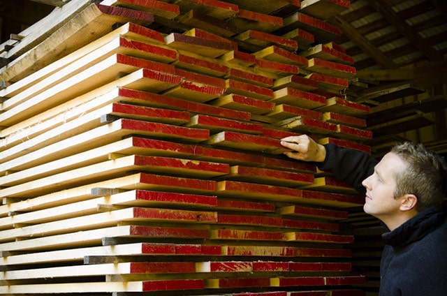 Joshua Farnsworth Inspecting Wood Lumber At A Lumber Yard In Virginia