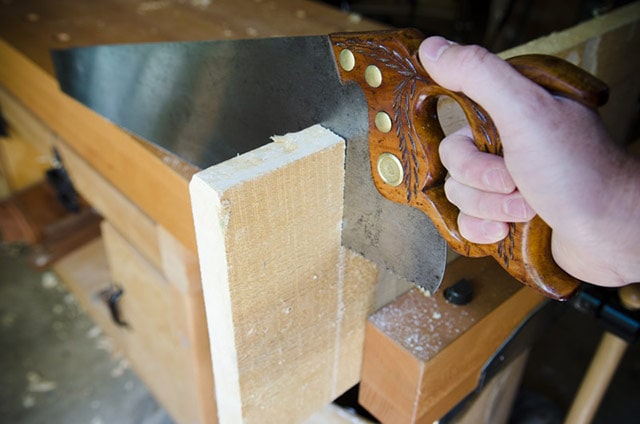 Using A Hand Saw To Cut Off A Board End To Flatten Board