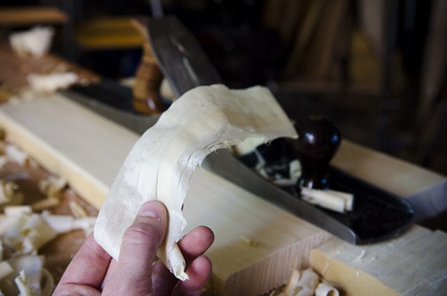 Flatten Board By Hand Planing With No. 7 Jointer Stanley Plane On A Wood Work Bench Showing Wood Shavings