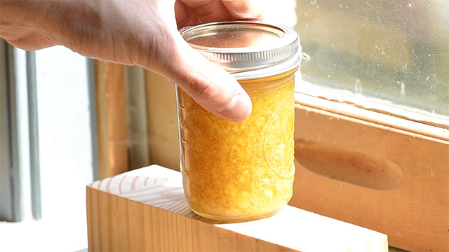 Jar of beeswax polish finish melting next to a sunny window