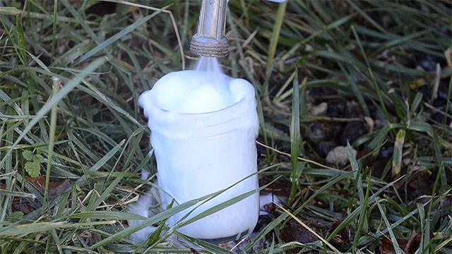 A Hose Spraying Water Into A Glass Jar To Dilute Toilet Bowl Cleaner That Was Stripping Wood Screws