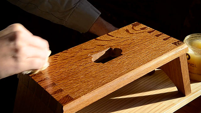 Applying beeswax furniture polish to a Moravian footstool