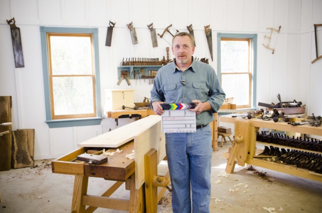 Will Myers Holding A Clapper Board Slate On Set While Filming A Dvd About Making A Collapsiable Trestle Table In Joshua Farnsworth'S Woodworking Workshop