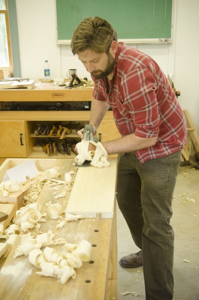 An Bearded Woodworking Student Using An Antique Stanley 7 Jointer Plane At A Woodworking Workbench