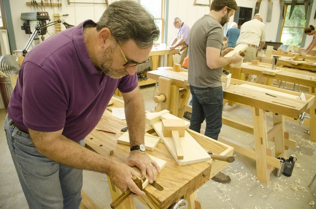 A Male Woodworking Student Using A Mortise Gauge To Layout Dovetail Joints