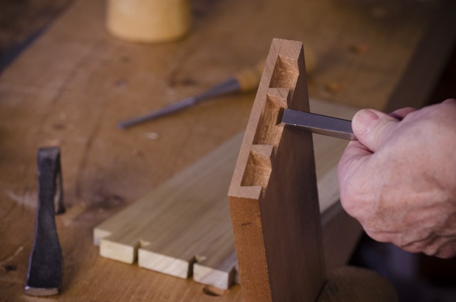 James Hugget Making A Half Blind Dovetails Joint For Drawers Out Of Mahogany Drawer Front And Poplar Wood Sides, With Chisels And A Mallet On A Woodworking Workbench