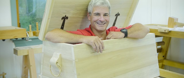 Tom Calisto Popping His Head And Arms Out Of An Angled Dovetail Sailor Tool Chest In Joshua Farnsworth'S Traditional Woodworking School