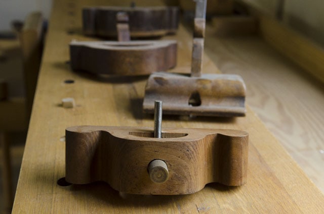 Antique Wooden Router Planes Sitting In A Row On A Woodworking Workbench