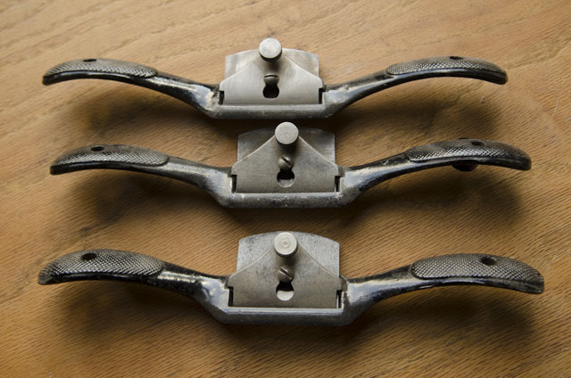 Three Stanley 51 Spokeshaves Sitting On A Woodworking Workbench In A Row