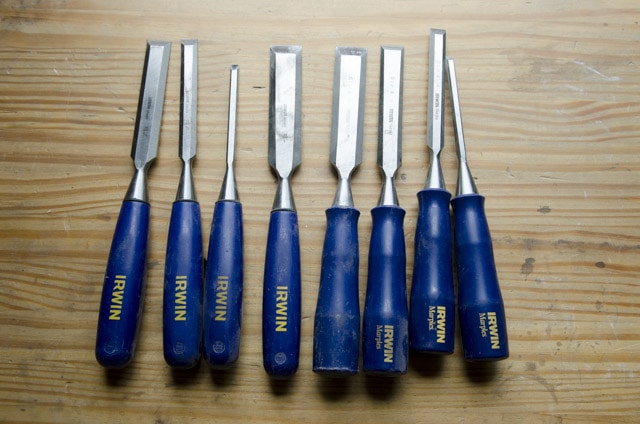 Irwin Chisel Set: Marples Bench Chisels With Blue Handles Sitting On A Woodworking Workbench Top