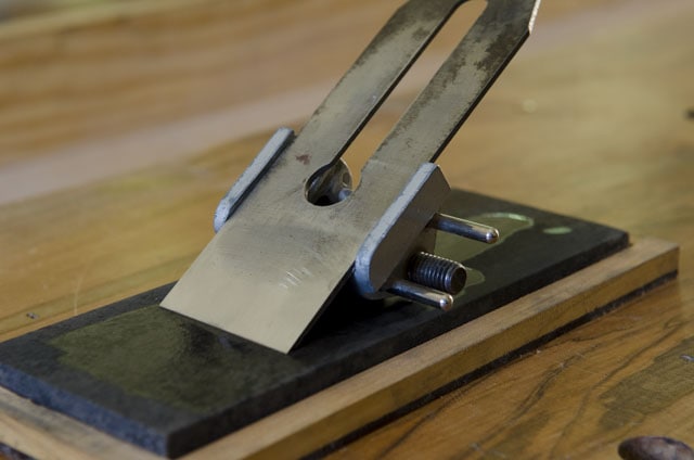 Side Clamp Honing Guide Used For Sharpening A Woodworking Hand Plane On An Oil Sharpening Stone