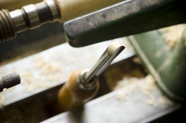 Detail Spindle Gouge With A Wood Lathe In The Background