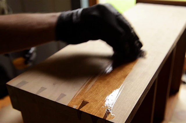 Woodworker Applying Danish Oil To A Dovetail Cupboard Case Piece