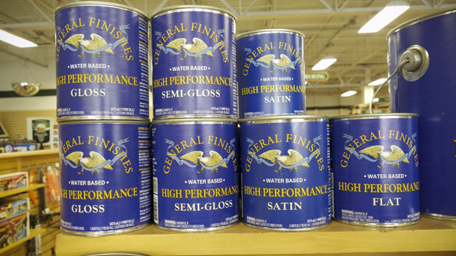 Quart And Pint Cans Of General Finishes High Performance Water Based Wood Finish Stacked On A Woodworking Store Shelf