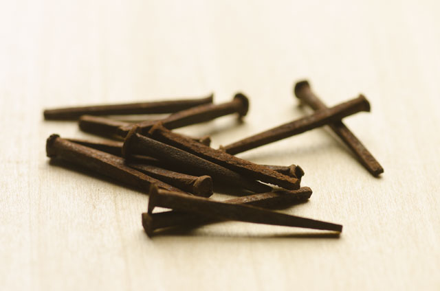 Rusted Antique Cut Nails Sitting On A Piece Of Wood
