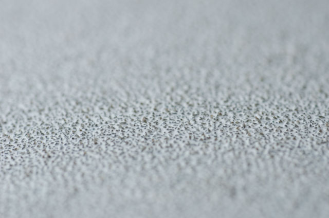 Macro closeup photo of 80 grit sandpaper surface