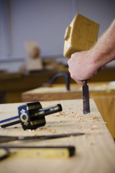 Woodworker Using A Chisel And Joiner'S Mallet To Make A Portable Moravian Workbench