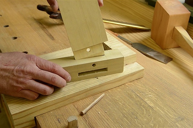 Woodworker Inserting A Tenon Into A Mortise On A Table Leg Mortise And Tenon Joint