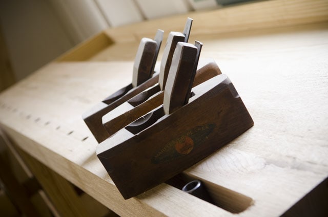 Three Antique Wooden Coffin Smoother Smoothing Planes Sitting On A Moravian Workbench