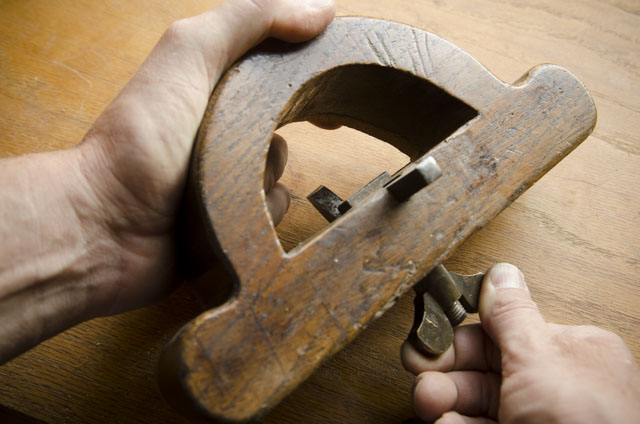 Fingers Tightening The Thumb Screw Of A  Wooden Router Plane
