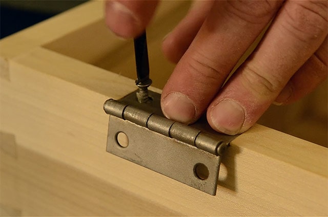Driving Screws With A Screw Driver While Installing Butt Hinges On A Dovetail Chest