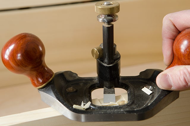 A Woodworker Using A Veritas Router Plane To Cut A Recess For A Hasp On A Wooden Dovetail Chest Box