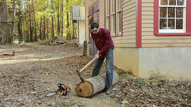 Elia Bizzarri Using A Sledge Hammer And Wood Splitting Wedge And Chainsaw To Split A Log