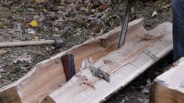 Using A Chainsaw To Clear Fibers To Split A Log 