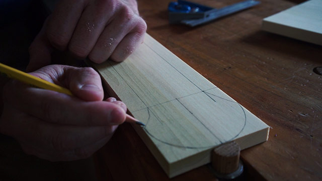Using A Pencil To Draw Handle Curves On A Wooden Pizza Peel