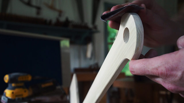 Using Sandpaper To Sand The Handle Of A Wooden Pizza Peel